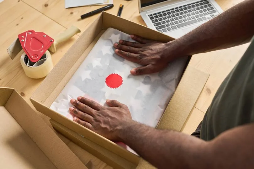 small business owner packs his product with his logo and branding on it